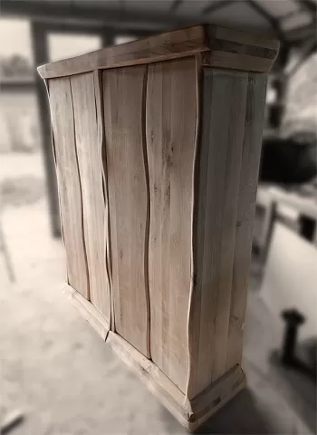 Ručno rađena vinska polica od punog hrastovog drveta sa karakterističnim talasastim ivicama i prirodnom teksturom drveta. Rustičan, a moderan dizajn ormarića za vino visokog kvaliteta, fotografisan u stolarskoj radionici.